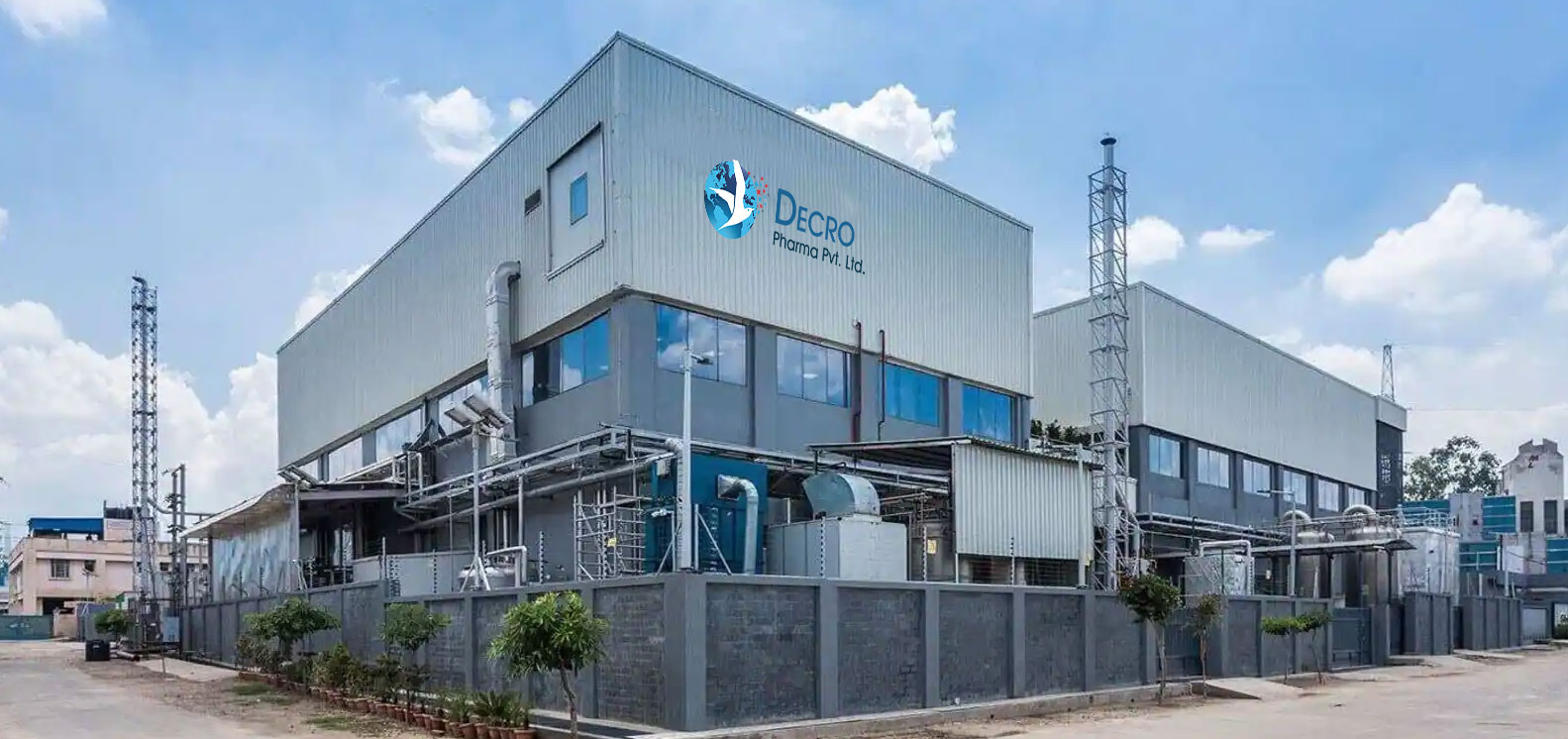 The Decro Pharma manufacturing plant at Umiya Industrial Estate, Indrad, with the company emblem on the facade