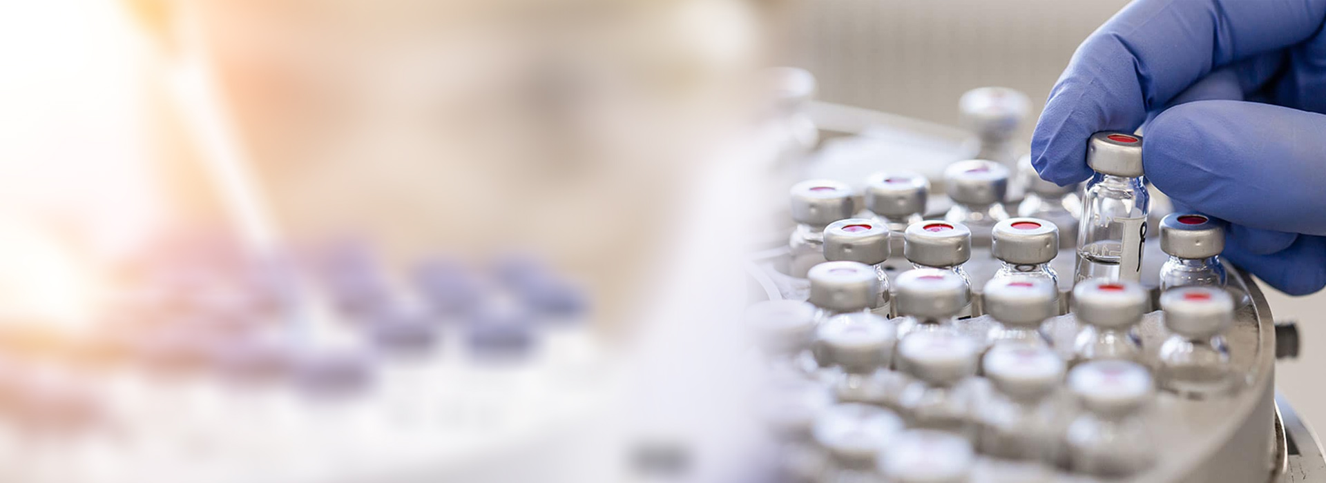 A technician in sterile gloves loading vials into a lyophiliser at the Decro Pharma facility